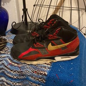 Black men Nikes with gold red design .